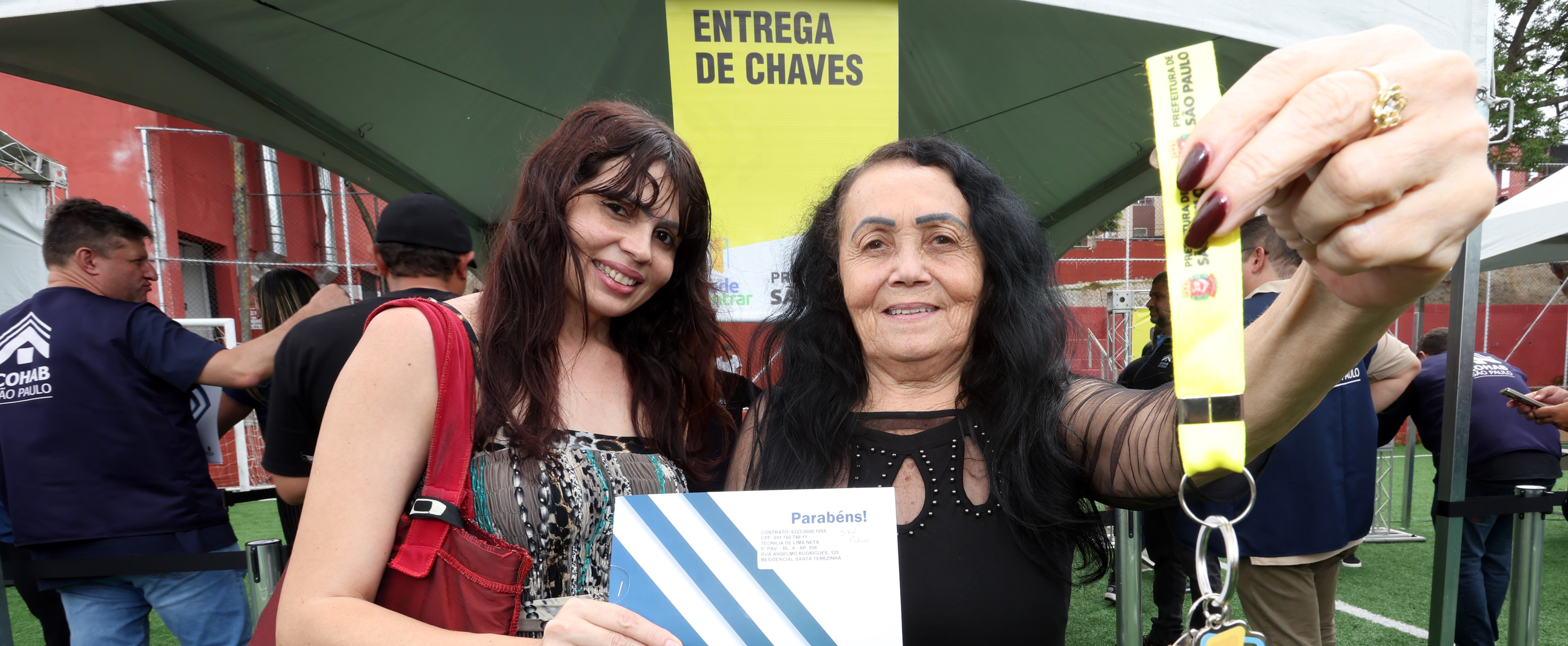 Duas mulheres seguram a chave de seu novo apartamento