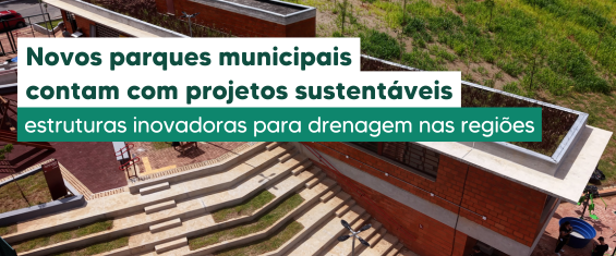 Imagem horizontal de um parque visto de cima. No centro, há arquibancadas em degraus de concreto bege. À direita, aparece um prédio com paredes de tijolo vermelho e cobertura clara. No topo da imagem, há área verde com grama em tons de verde claro e escuro. No lado esquerdo, uma faixa verde-escura com texto em branco informa que novos parques municipais contam com projetos sustentáveis e estruturas inovadoras para drenagem.