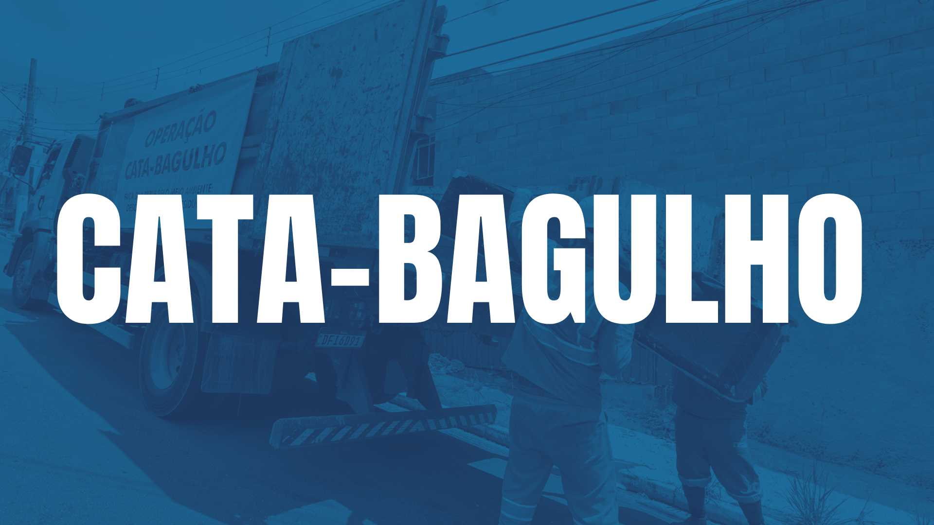 A imagem apresenta um plano de fundo em tons de azul com uma fotografia filtrada em tons monocromáticos de um ambiente de coleta urbana. Em primeiro plano, dois funcionários uniformizados aparecem de costas, manuseando e levantando o que parece ser um item volumoso, como um móvel velho, para dentro da caçamba de um caminhão de lixo. O caminhão está estacionado na rua, e ao fundo se vê uma parede de tijolos e fios de energia. Centralizado e em grande destaque, há um texto na cor branca, escrito em letras maiúsculas com uma fonte alta e robusta, que diz: CATA-BAGULHO. À esquerda, sobre o caminhão, é visível uma placa com a frase OPERAÇÃO CATA-BAGULHO em letras menores. O conjunto visual utiliza o contraste do branco sobre o azul para comunicar de forma clara uma iniciativa de coleta de resíduos volumosos.